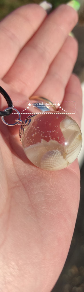 Resin pendant in the shape of a sphere, with shells