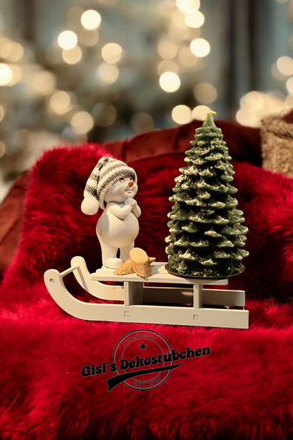 Christmas decorations with sled, snowman, Christmas tree candle and green wooden slices