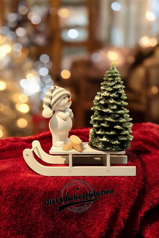 Christmas decorations with sled, snowman, Christmas tree candle and green wooden slices